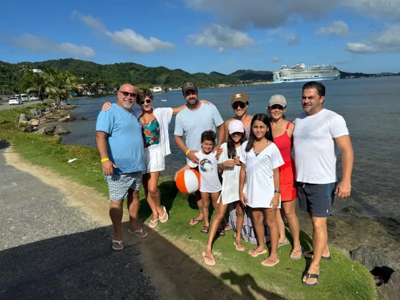 Multi-generation family on coastal road with cruise ship in the bay
