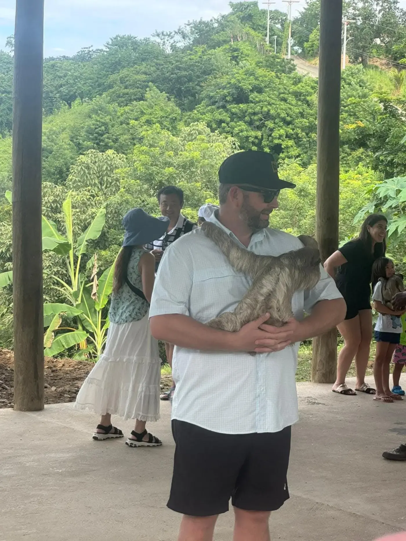 Tourist with sloth under jungle pavilion on island tour
