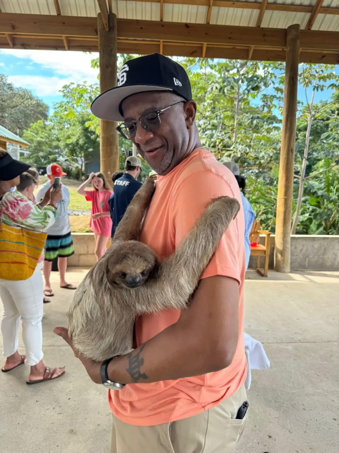 Guest smiling while holding a sloth at Roatán sanctuary